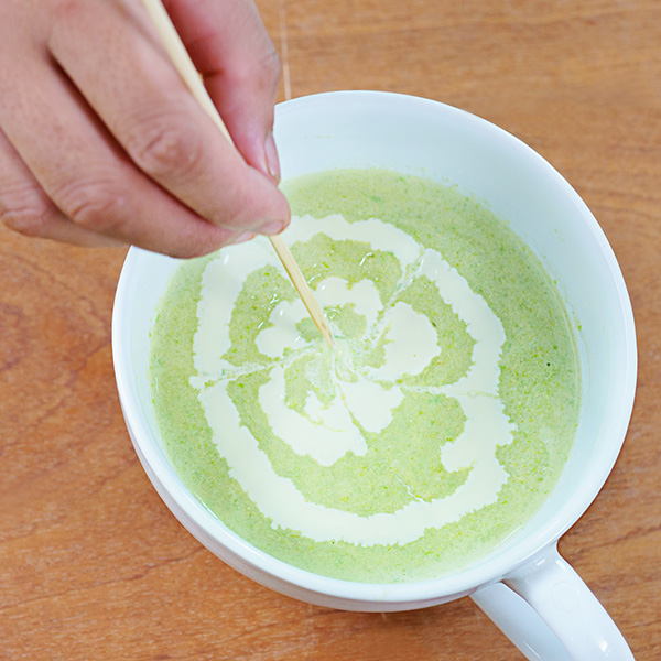 Cho súp ra tô, trang trí cùng sữa và hành ngò.